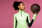 A Woman Holding A Basketball In Front Of A Pink Background